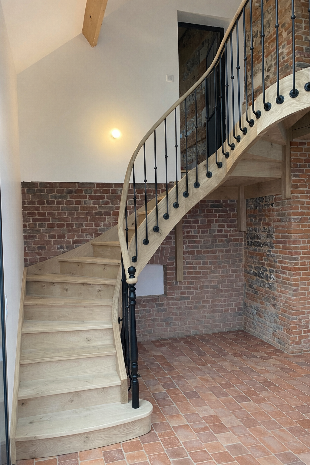 Escalier balancé en bois avec balustres métalliques dans une maison en brique